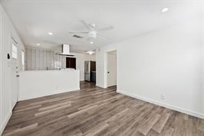 unfurnished living room featuring ceiling fan and dark hardwood / wood-style flooring