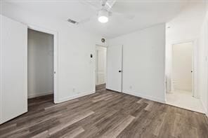 unfurnished bedroom featuring ceiling fan, a closet, connected bathroom, and dark hardwood / wood-style flooring