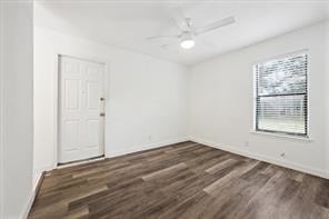 unfurnished room with ceiling fan and dark hardwood / wood-style flooring