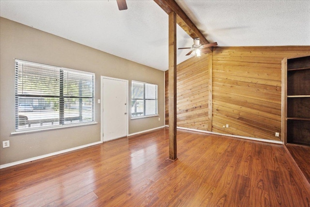300 Tilbury Ln, Austin, TX 78745 - unfurnished living room with a ceiling fan, wood walls, and wood finished floors