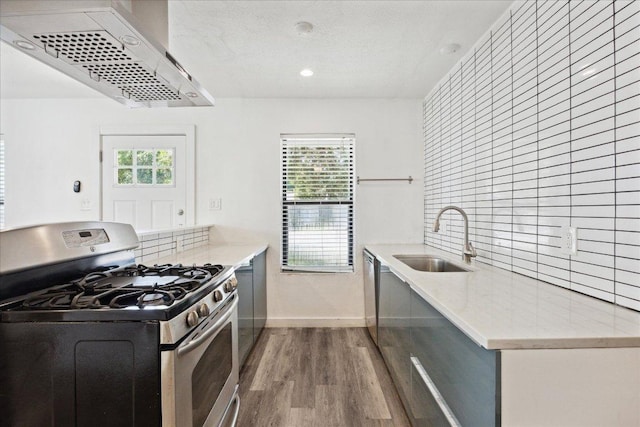 300 Tilbury Ln, Austin, TX 78745 - kitchen with gas stove, extractor fan, wood finished floors, light stone countertops, and recessed lighting