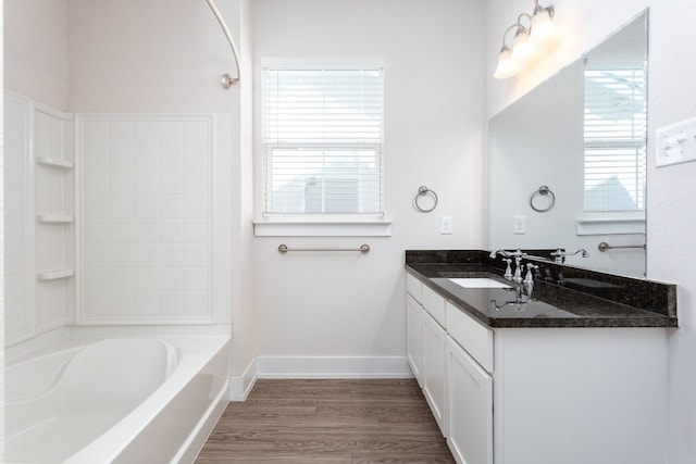 bathroom featuring hardwood / wood-style flooring, vanity, and washtub / shower combination