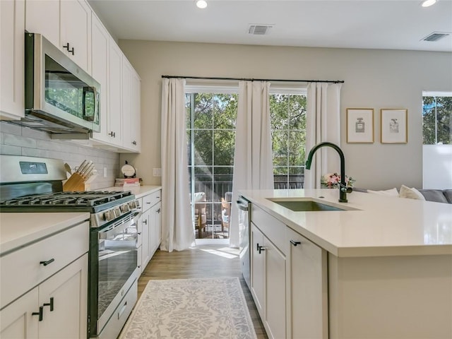 3809 Valley View Rd Unit 1, Austin, TX 78704 - kitchen featuring appliances with stainless steel finishes, recessed lighting, light countertops, tasteful backsplash, and light wood-style flooring