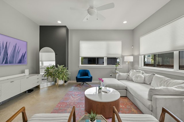 living room featuring ceiling fan and concrete floors