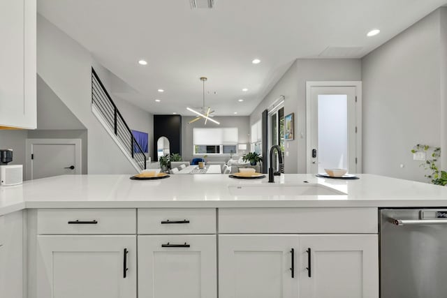 kitchen featuring white cabinetry, dishwasher, light stone countertops, and sink