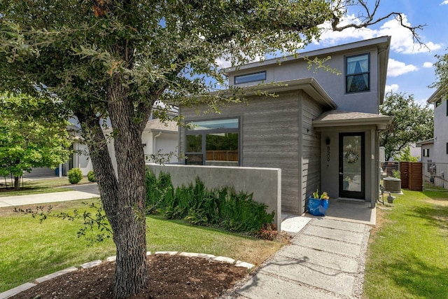 view of front of property with a front lawn and cooling unit