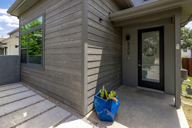 property entrance with central AC and a patio