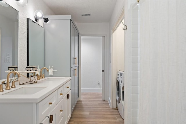 200 Shady River Rd, Wimberley, TX 78676 - bathroom with wood finished floors, washer / clothes dryer, double vanity, and baseboards