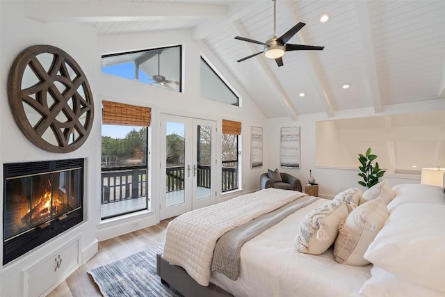 200 Shady River Rd, Wimberley, TX 78676 - bedroom with access to outside, french doors, beamed ceiling, wood finished floors, and a glass covered fireplace