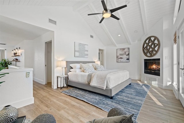 200 Shady River Rd, Wimberley, TX 78676 - bedroom with high vaulted ceiling, a glass covered fireplace, light wood-type flooring, baseboards, and ceiling fan