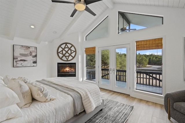 200 Shady River Rd, Wimberley, TX 78676 - bedroom with french doors, access to outside, beamed ceiling, wood finished floors, and a glass covered fireplace