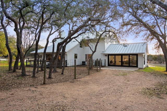 200 Shady River Rd, Wimberley, TX 78676 - back of house featuring stucco siding, a standing seam roof, metal roof, and central air condition unit