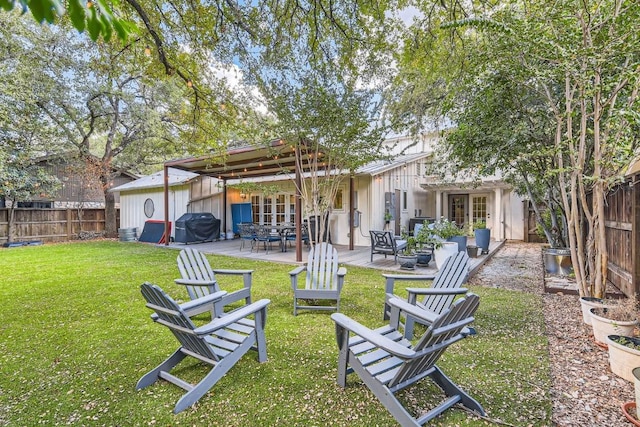 rear view of property with french doors, an outdoor living space, a patio, and a lawn