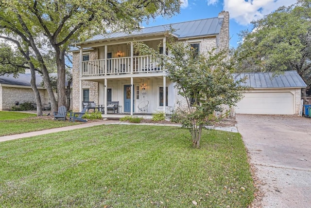 view of front of house with a balcony, a chimney, metal roof, a standing seam roof, and covered porch