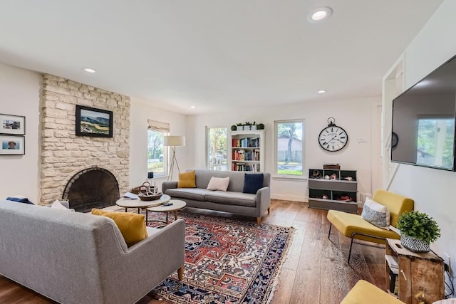 living room featuring hardwood / wood-style floors and a stone fireplace