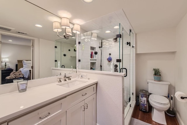 bathroom with toilet, vanity, wood-type flooring, and walk in shower