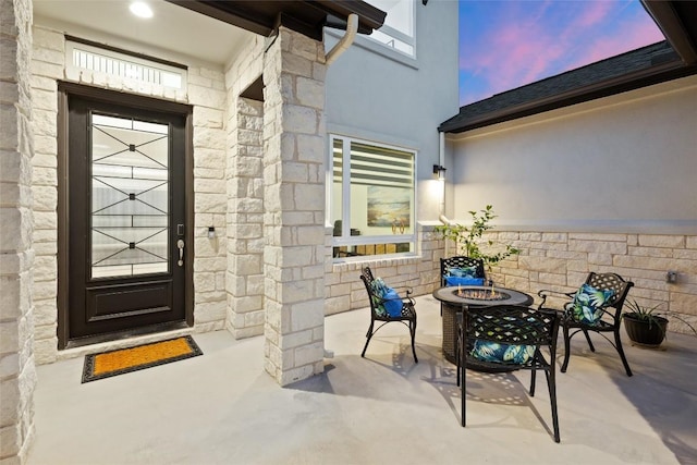 exterior entry at dusk with stone siding