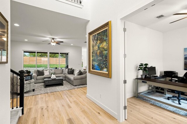 living room featuring light wood-style flooring, visible vents, ceiling fan, baseboards, and recessed lighting
