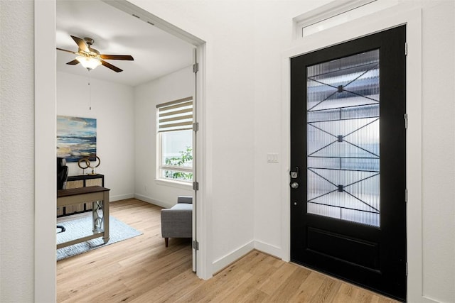 foyer with ceiling fan, light wood-type flooring, and baseboards