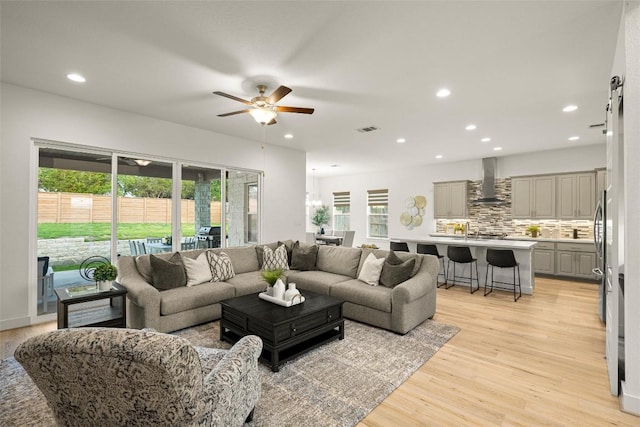 living room featuring visible vents, ceiling fan, plenty of natural light, and light wood finished floors