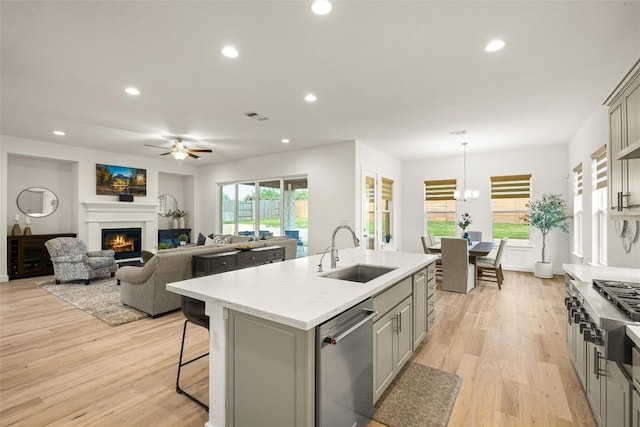 kitchen with appliances with stainless steel finishes, ceiling fan, gray cabinetry, and a sink