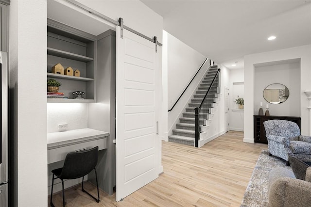 living area with light wood-style floors, a barn door, stairs, and recessed lighting