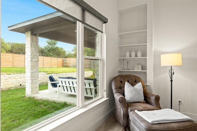 living area with baseboards and carpet floors