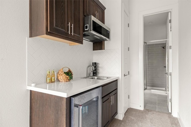 bar with stainless steel microwave, a sink, wine cooler, tasteful backsplash, and light colored carpet