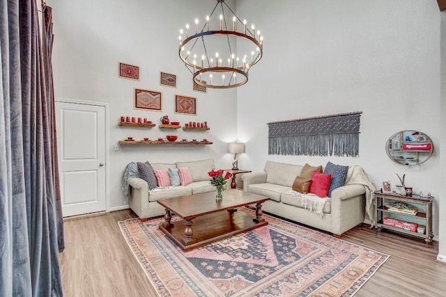 living room featuring hardwood / wood-style floors, an inviting chandelier, and a towering ceiling