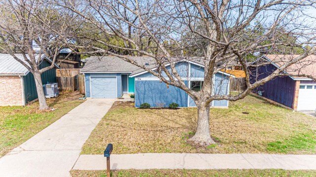 view of front of house featuring an attached garage, driveway, and a front lawn