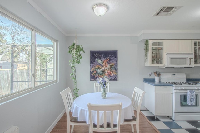 dining room featuring visible vents, crown molding, baseboards, and tile patterned floors