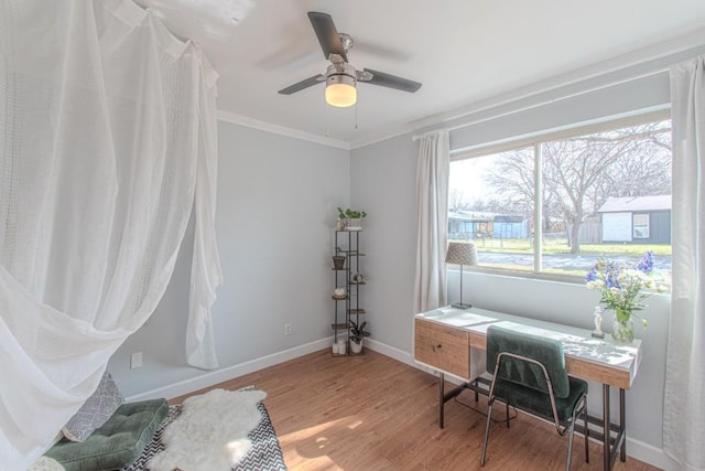 office space with ornamental molding, ceiling fan, baseboards, and wood finished floors