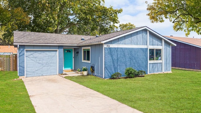 view of front of property featuring a garage, fence, driveway, a front lawn, and board and batten siding