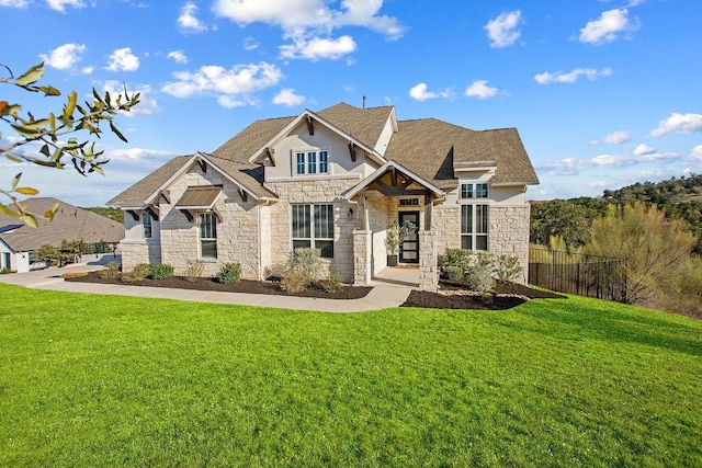 view of front of house featuring a shingled roof, a front lawn, and fence