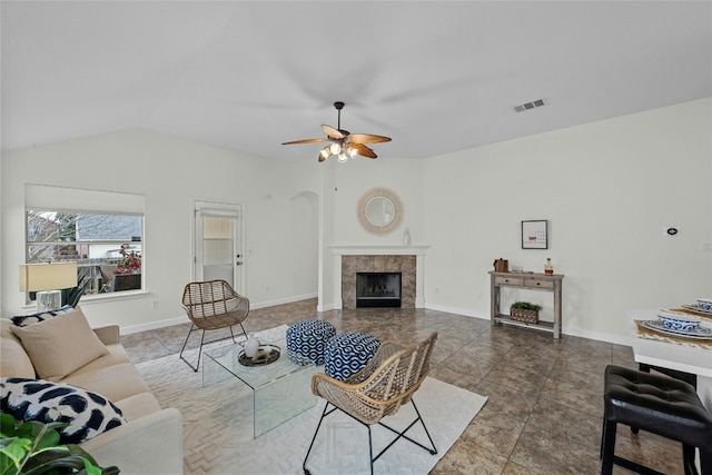 tiled living area with visible vents, ceiling fan, baseboards, lofted ceiling, and a fireplace