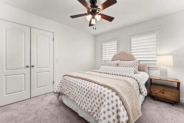 bedroom with light carpet, ceiling fan, and a closet