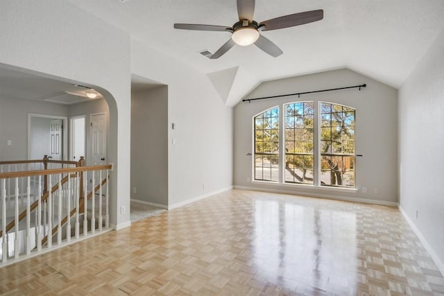 spare room with lofted ceiling, visible vents, arched walkways, and baseboards