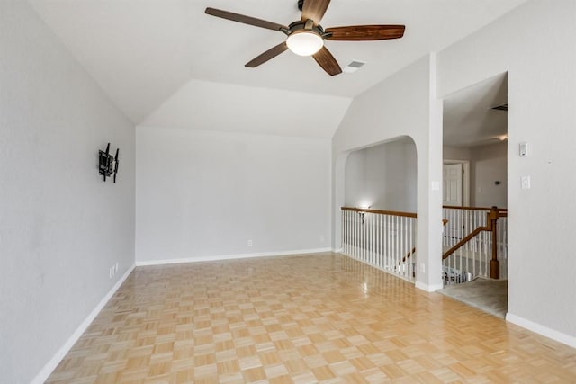 empty room featuring baseboards, lofted ceiling, visible vents, and ceiling fan