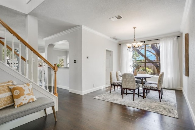 dining room featuring baseboards, dark wood finished floors, visible vents, a chandelier, and a textured ceiling