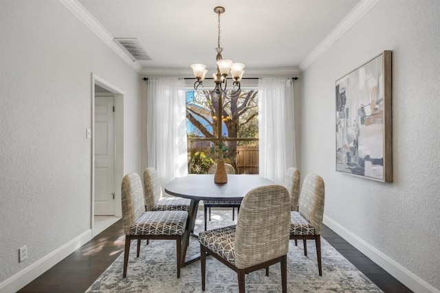 dining space featuring baseboards, dark wood finished floors, an inviting chandelier, visible vents, and ornamental molding