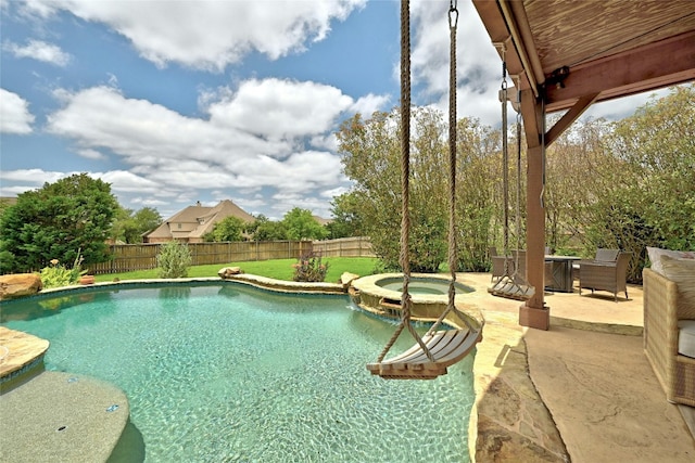 view of swimming pool with a patio area, a pool with connected hot tub, and a fenced backyard