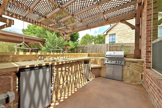 view of patio with exterior kitchen, a grill, a sink, and a pergola