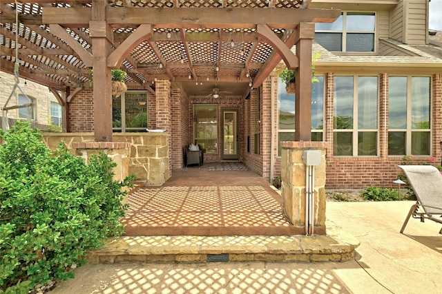 view of exterior entry featuring a patio area, brick siding, and a pergola