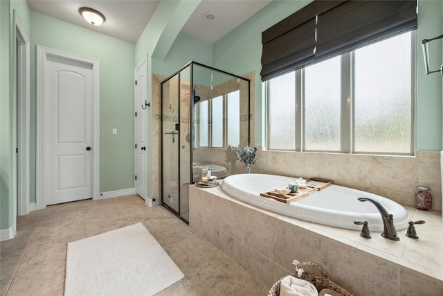 bathroom with tile patterned flooring, a garden tub, baseboards, and a shower stall