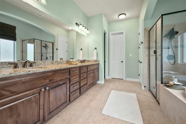 bathroom with tile patterned floors, double vanity, a shower stall, and a garden tub