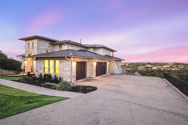 205 Palazza Alto Dr, Austin, TX 78734 - view of front of house with stone siding, driveway, an attached garage, a standing seam roof, and metal roof