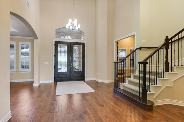 205 Palazza Alto Dr, Austin, TX 78734 - entryway featuring arched walkways, a towering ceiling, wood finished floors, french doors, and stairway