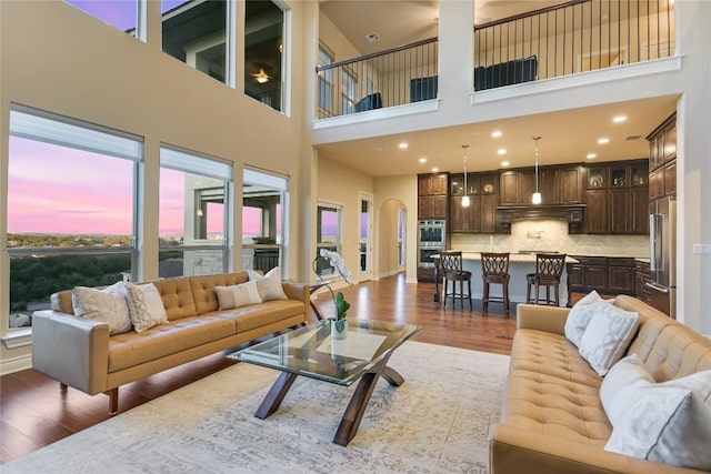 205 Palazza Alto Dr, Austin, TX 78734 - living room with dark wood-style flooring, a towering ceiling, arched walkways, and recessed lighting