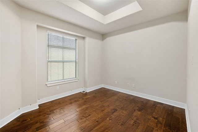 spare room featuring baseboards and wood finished floors