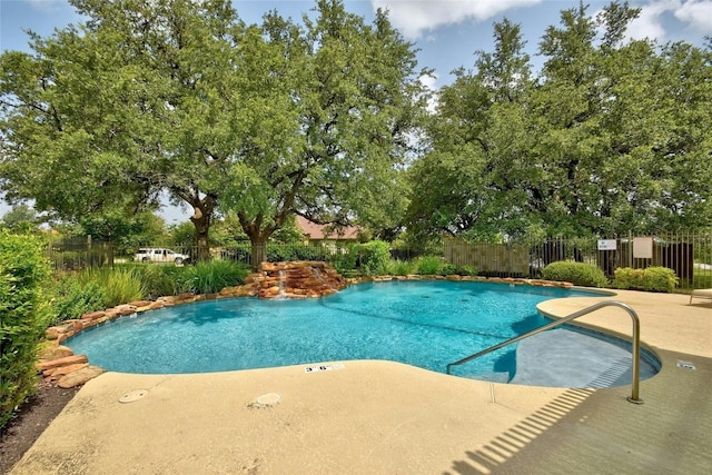 community pool with fence and a patio